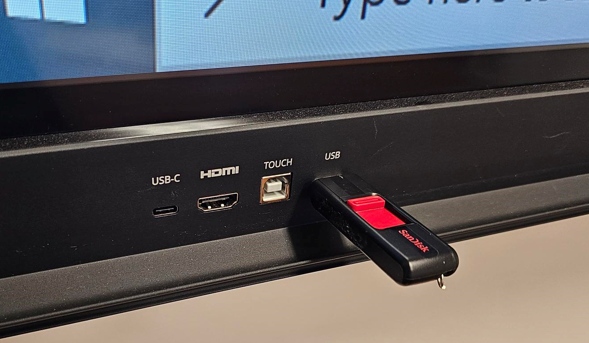 picture of a USB plugged into the USB port located to the bottom left on the front of the conference room display