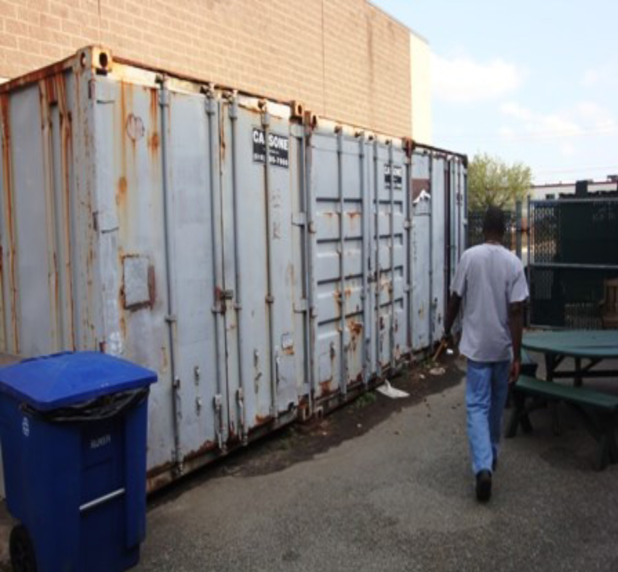 Man walking by a large storage container.